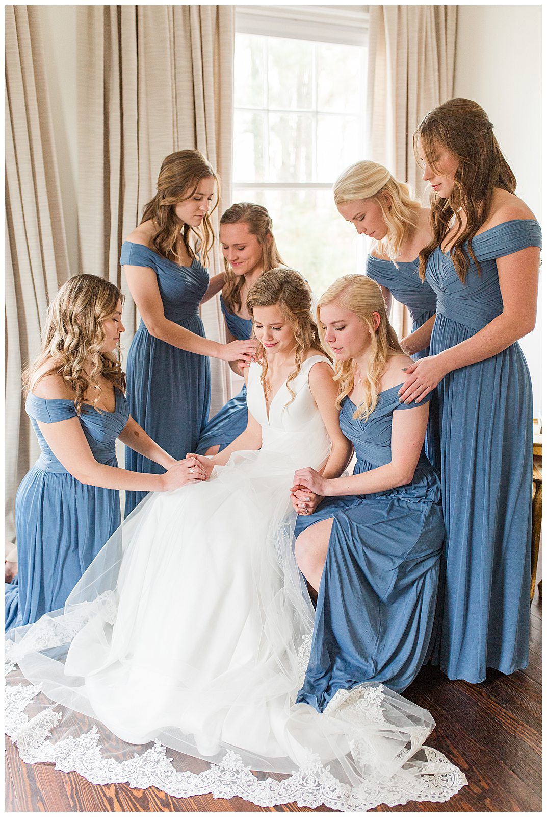 bride holds back tears as bridesmaids lay hands on her and pray