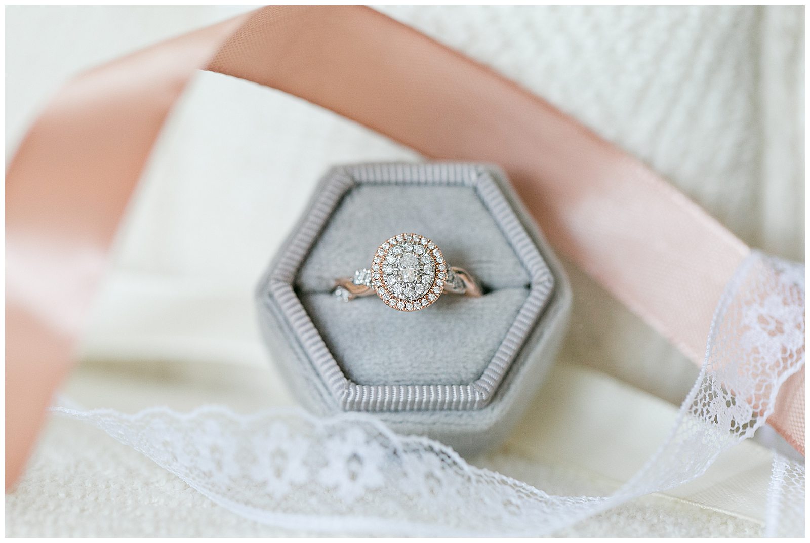 engagement ring in velvet ring box, surrounded by ribbon