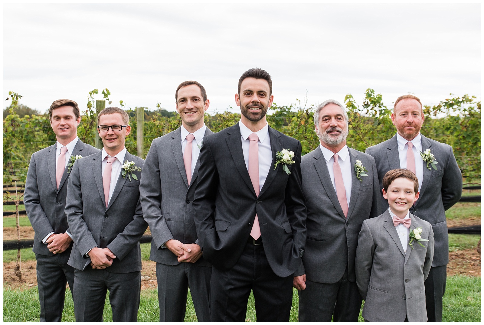 Grooms wedding party stands in front of the vines at childress vineyards weddings and events