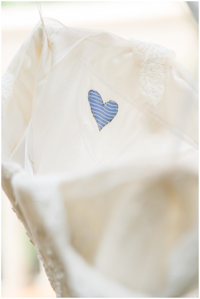 a small blue heart is sewn into the back of a wedding dress in memory of a loved one