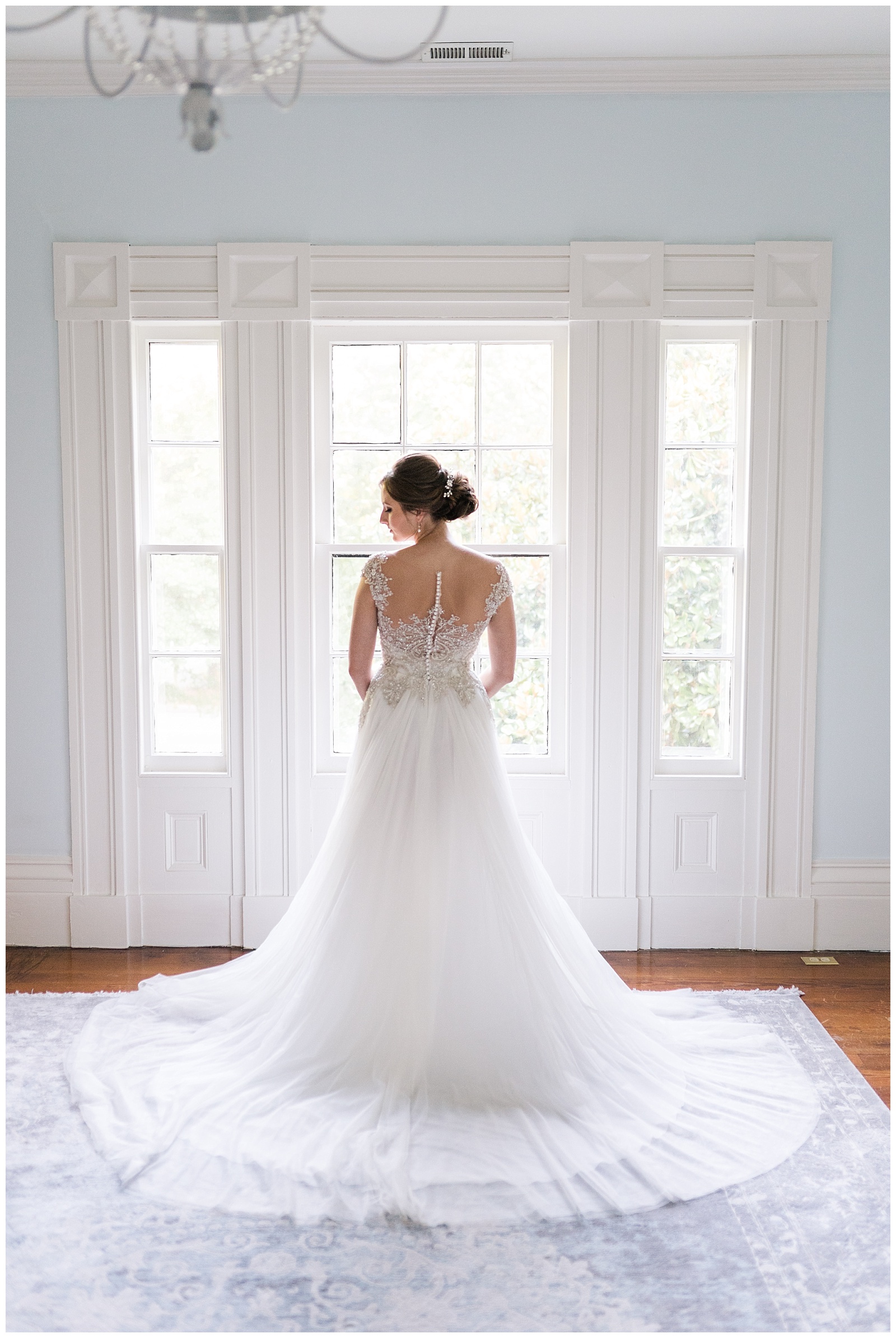 back of lace button up bridal gown in styled portrait session by bridal suite windows of historic wedding venue
