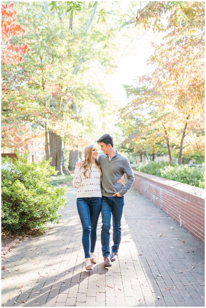 Raleigh NC couple poses with arm around each other for engagement portraits with jenn eddine