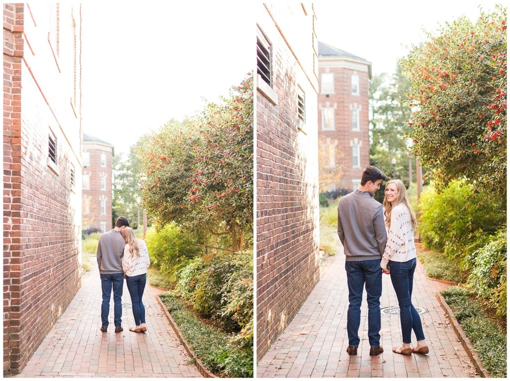 couple snuggles up and looks back at the engagement photographer over their shoulder