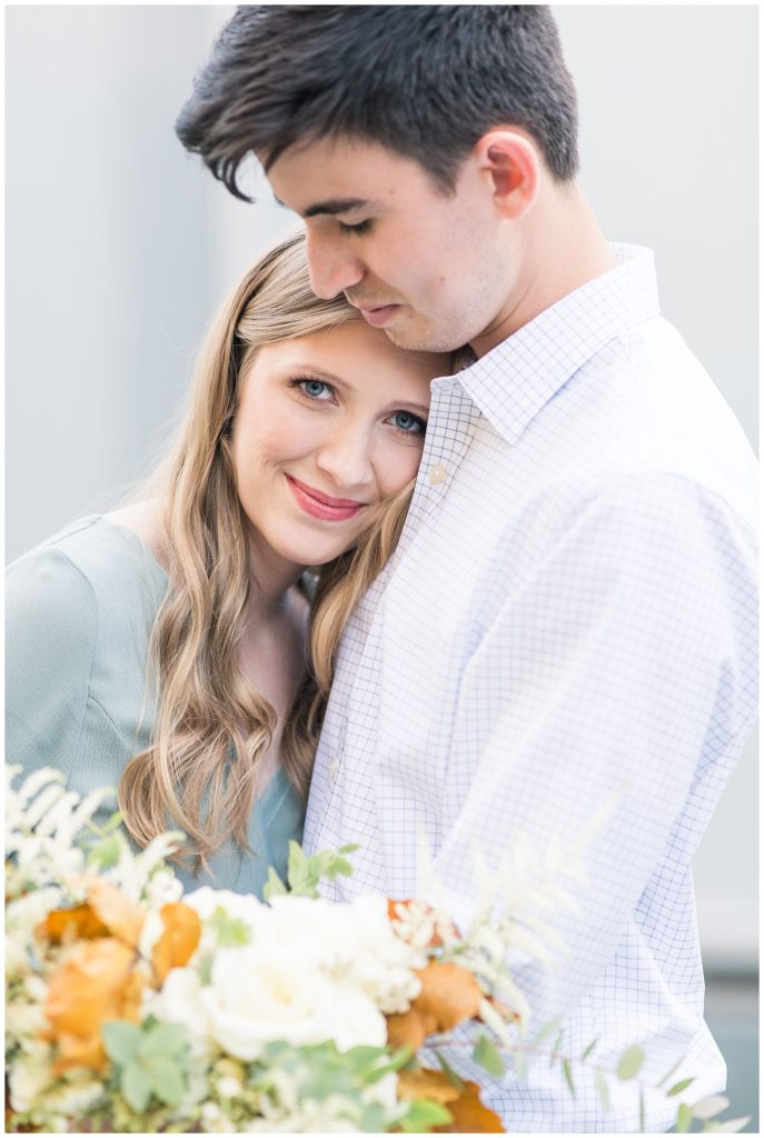 up close image of engaged couple holding each other close with beautiful matching bouquet