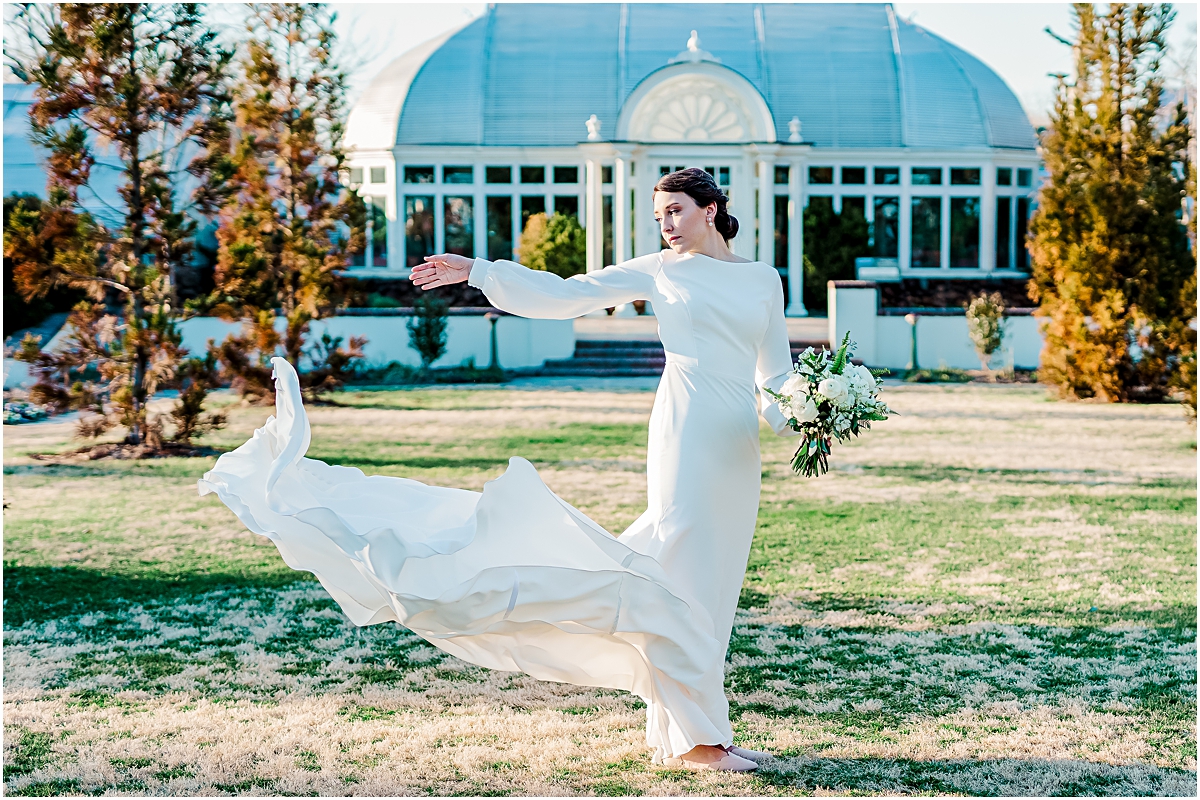 Eleanor throwing bridal train in front of greenhouse during Reynolda Gardens Bridal Session