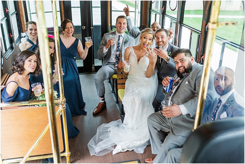 Amber and Chase riding in the trolley with their bridal party during their Greensboro wedding
