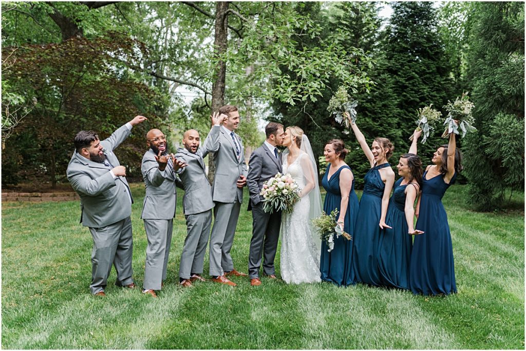 Amber and Chase kissing while their bridal party cheers them on