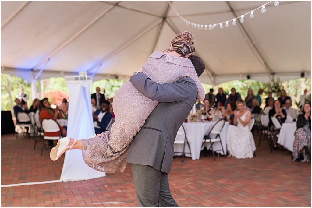 Couple dancing and swinging each other around during their Greensboro wedding