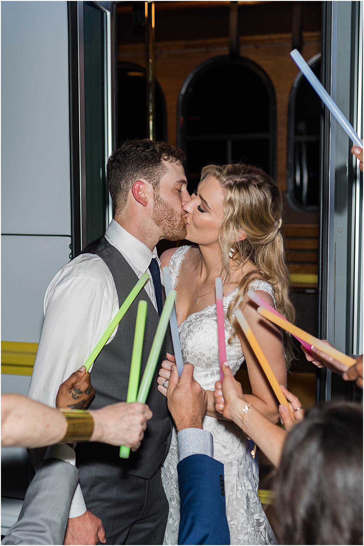 Amber and Chase kissing with lots of glowsticks around them during their Greensboro wedding