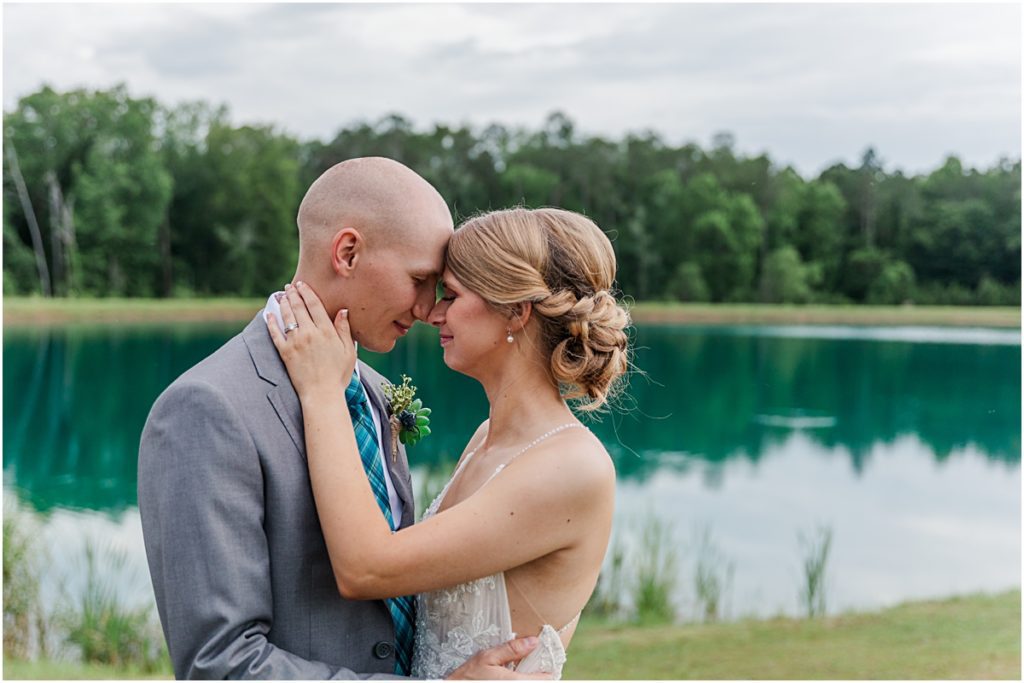 Luke and Brynn nuzzling in front of the lake taken by a wedding photographer