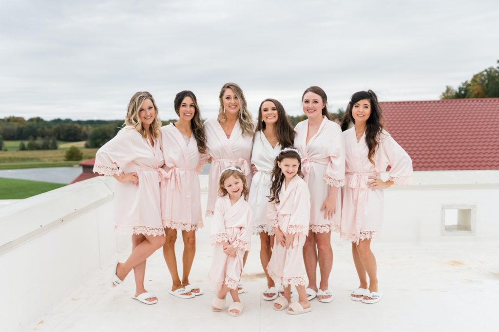 The bride with her bridesmaids and flower girls in their getting ready robes on the roof of Childress Vineyards.