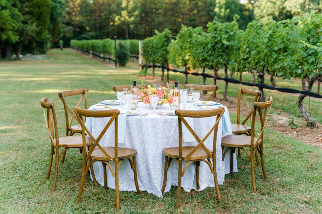 A textured neutral cloth covered table in the middle of a vineyard at Curran Alexander Vineyards.