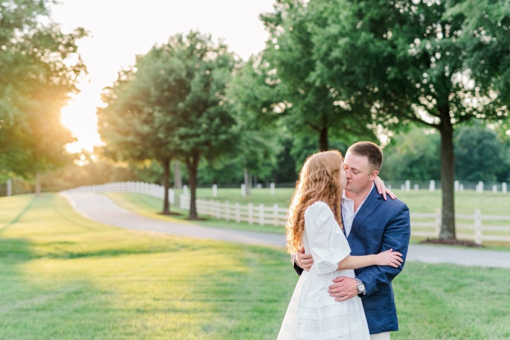 A man and woman kissing each other during golden hour at Adaumont Farm during their engagement session
