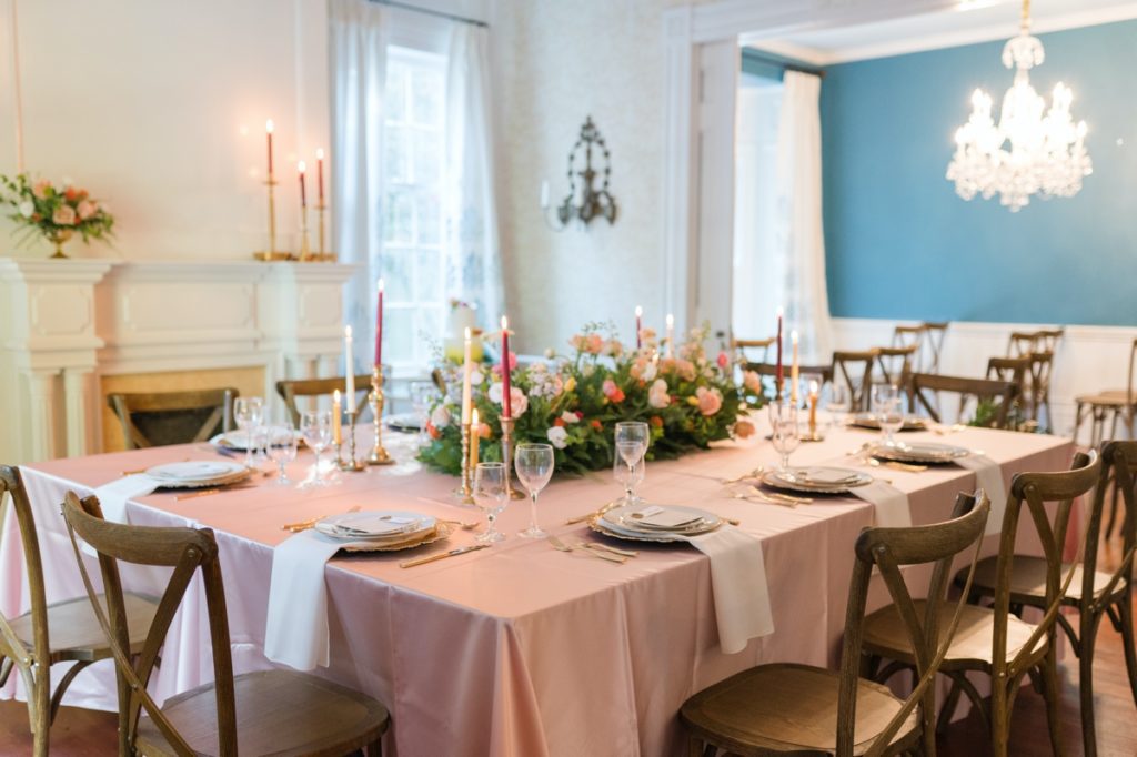 A pink cloth covered table in a blue reception room at Holt House in Lexington, NC.