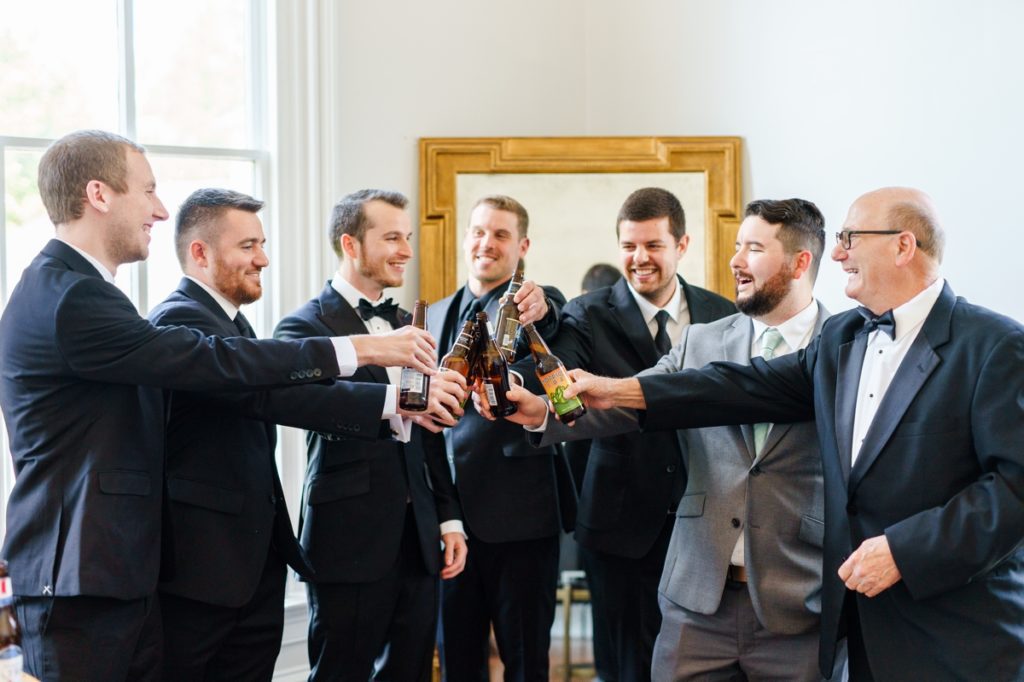 The groom toasting with his groomsmen in the grooms suite at Merrimon Wynne.