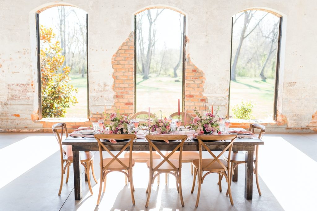 Detail photo of a blush tables-cape set up in front of a wall of open windows at Providence Cotton Mill.
