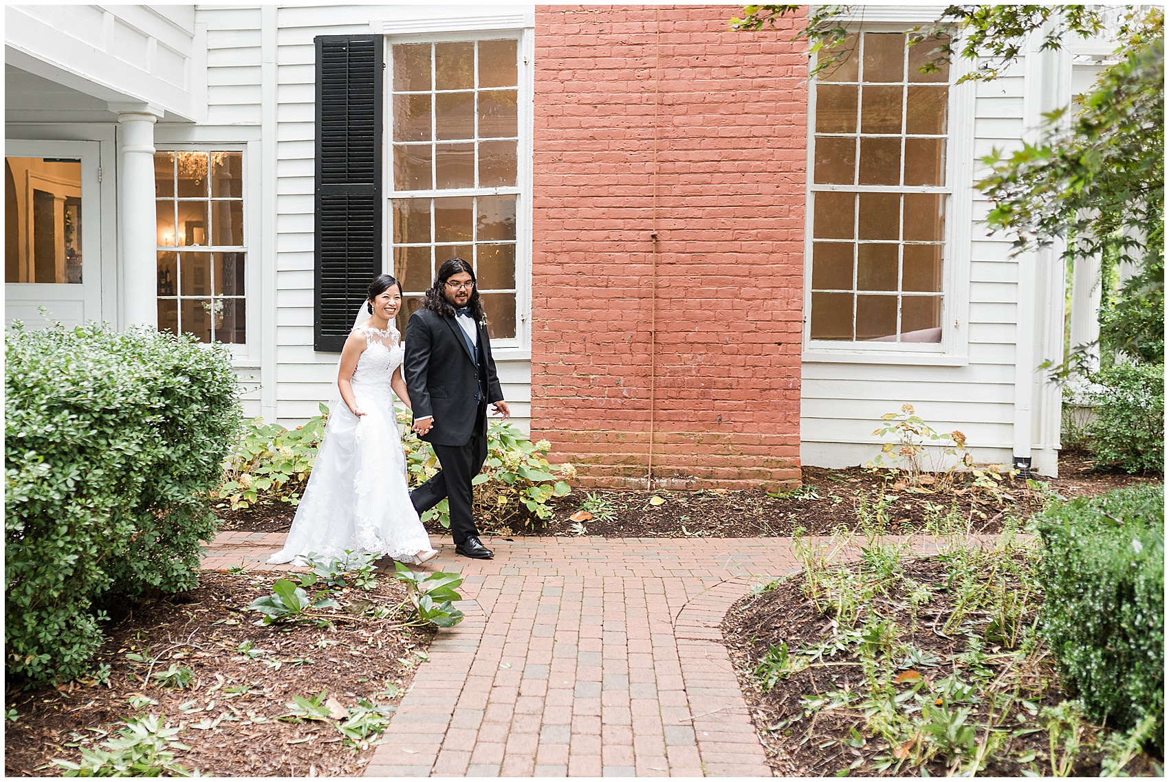 bride and groom walking along a path at their A Stunning and Historic Leslie Alford Mims House Wedding