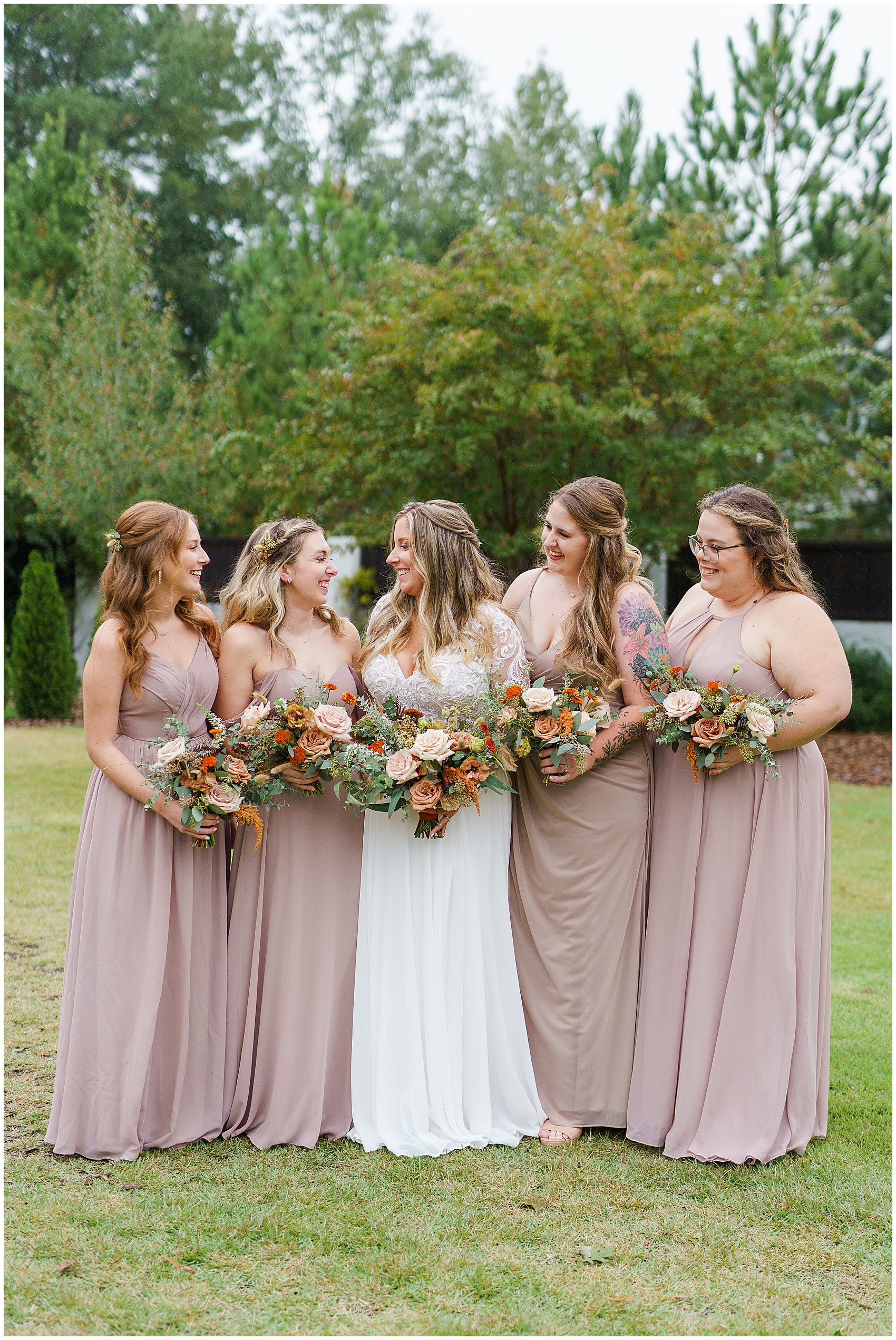 bride and her bridesmaids in blush dresses laughing at The Bradford Wedding Venue
